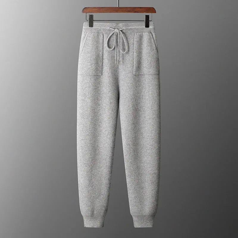 Man wearing a light grey hooded cashmere sweatshirt and matching casual trousers.