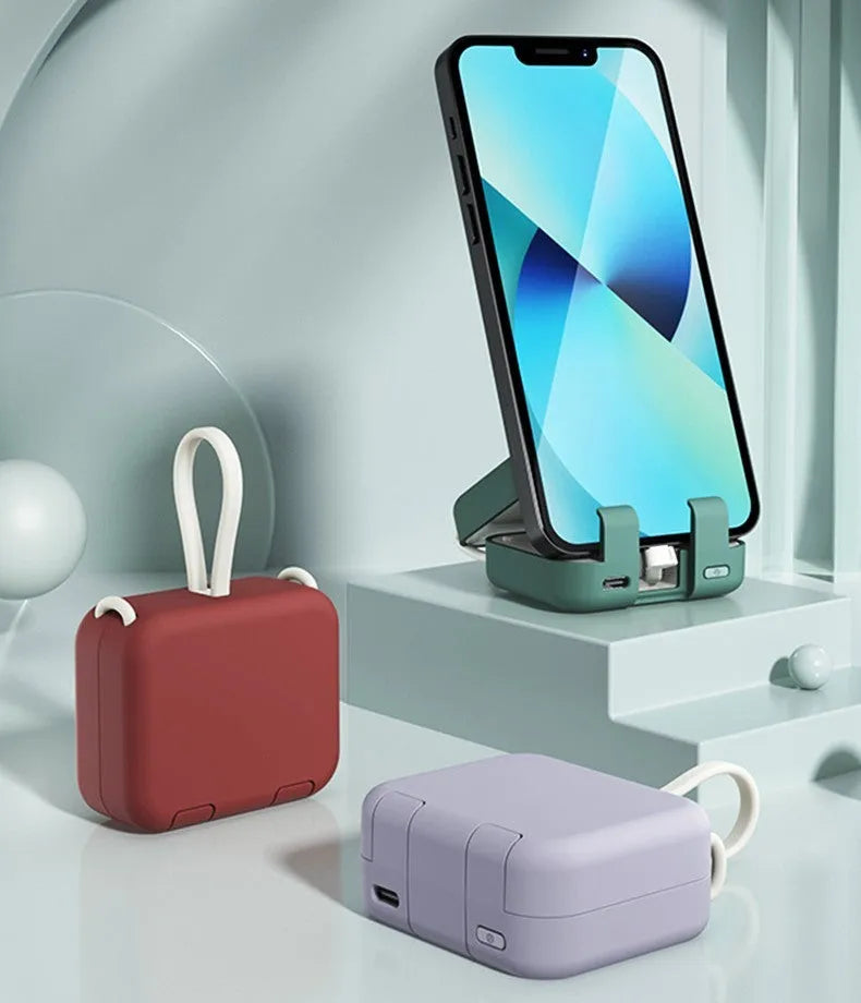 Red multi-function bracket mobile power supply showing USB-C and Lightning ports and integrated phone holder.