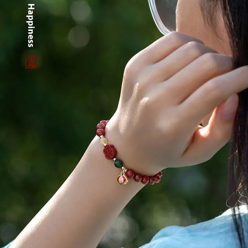 Close-up of a cinnabar Happy Eyebrow bracelet with Emperor Sandstone beads and a carved Fu character.