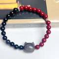 Handcrafted obsidian bracelet with colourful gemstone beads and silver cat charm on wrist