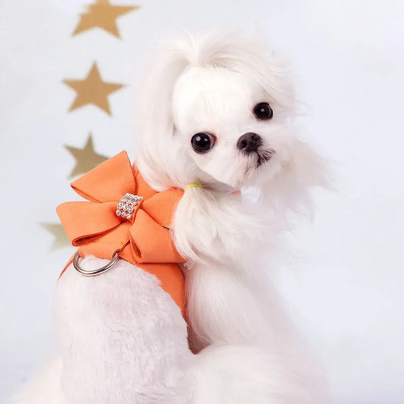 Close-up of a pink microfiber dog chest strap with a white bowknot and an adjustable metal buckle.