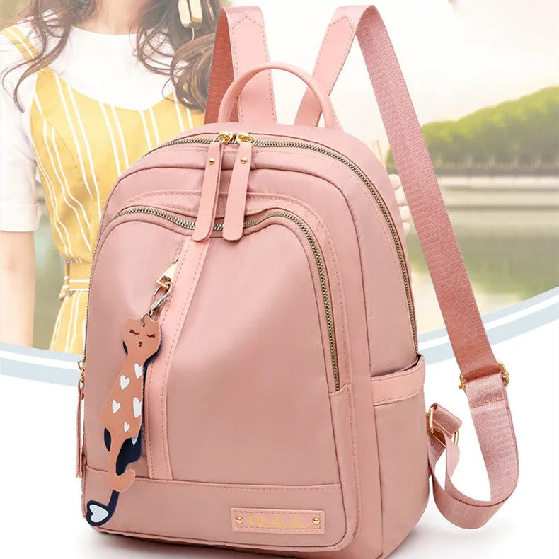 Black and pink views of a women's casual nylon backpack with double straps, a soft handle, and an external pocket.