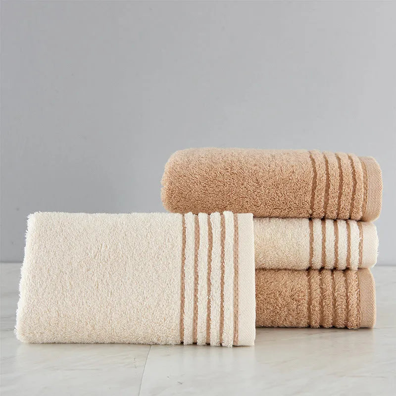 Beige and brown cotton towel set showing face cloth, hand towel and bath towel sizes.