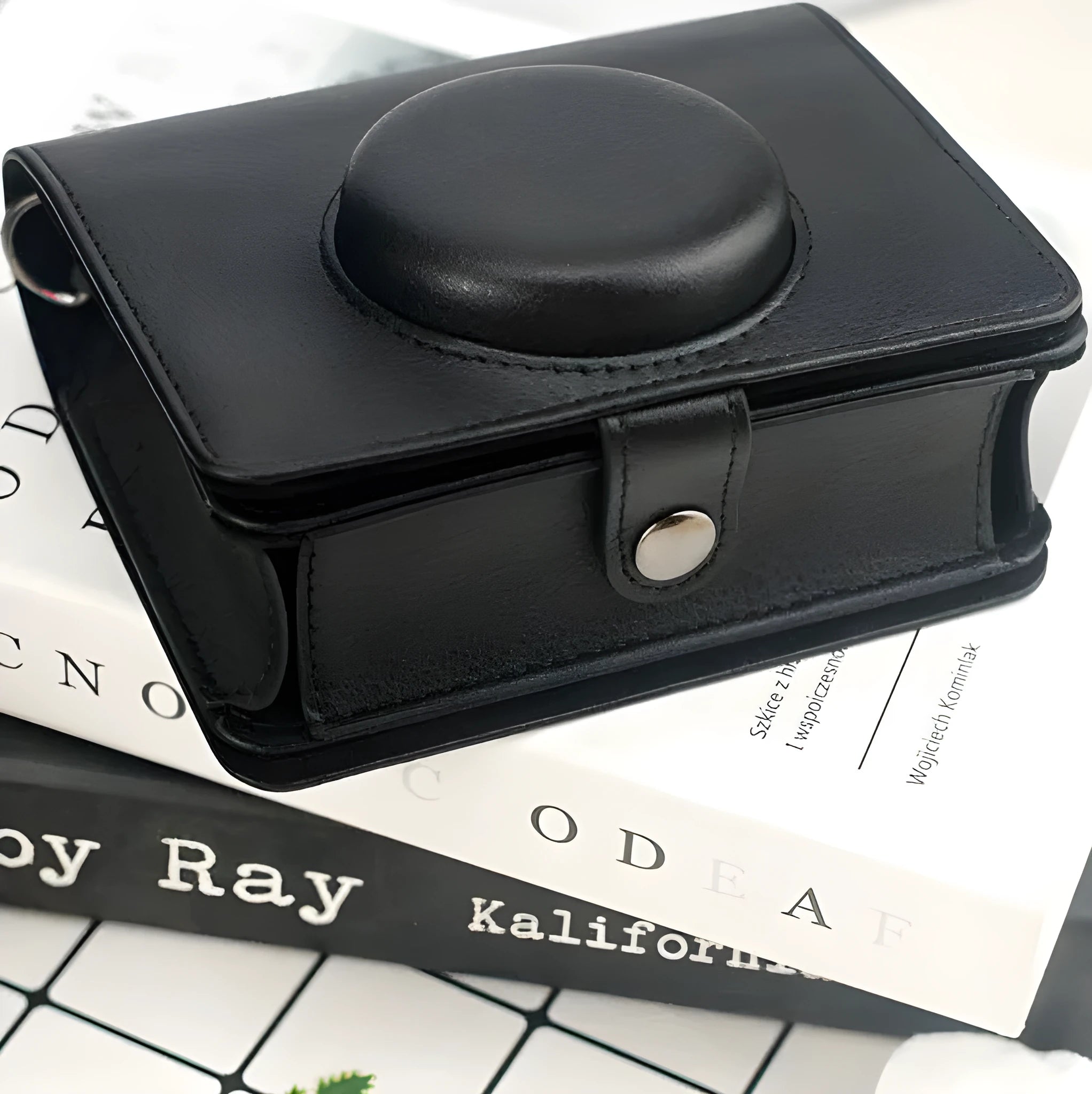 Retro camera storage case with curved shoulder strap in solid colour options including black skin feeling material