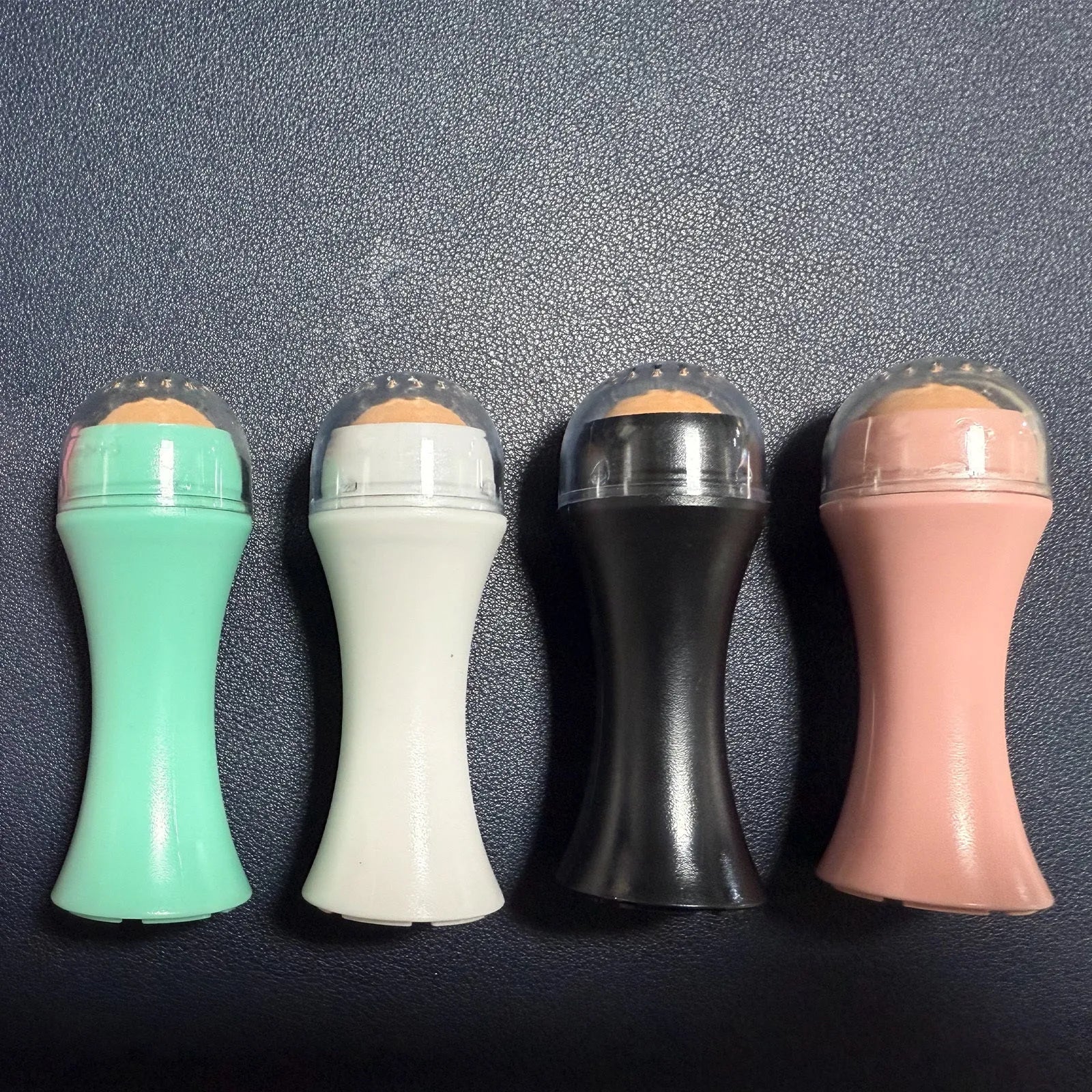 Portable volcanic stone roller for oily skin control in black, green, pink or white