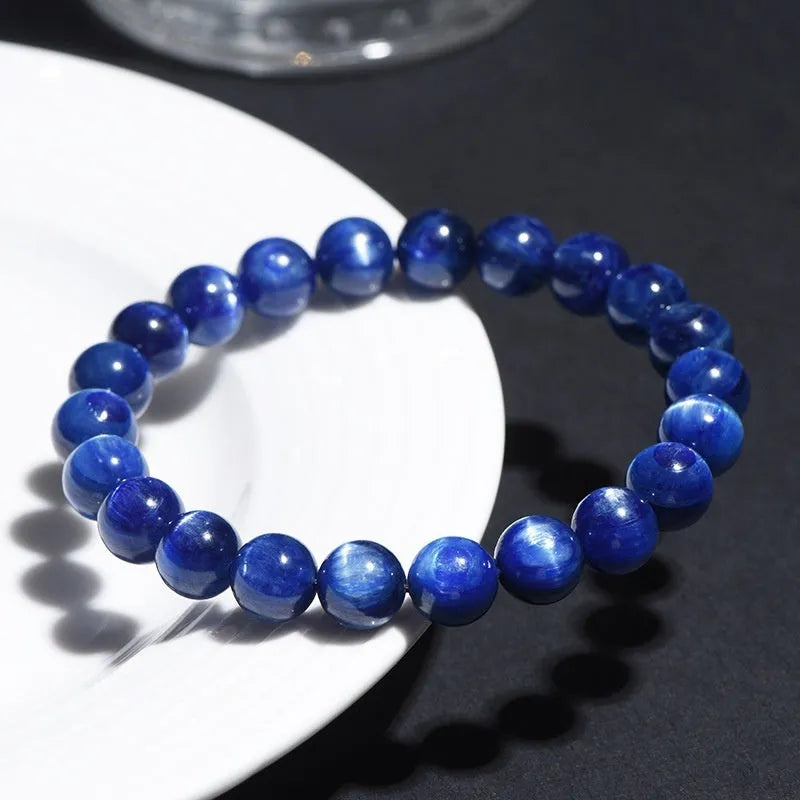 Polished blue crystal bracelet with geometric beads and Ruyi charm, shown in trade fair gifting context
