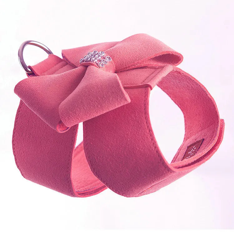 Close-up of a pink microfiber dog chest strap with a white bowknot and an adjustable metal buckle.