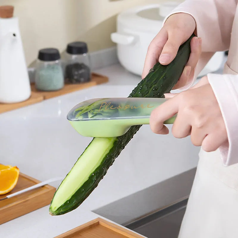 Dark green vegetable peeler with stainless steel blade stored inside a transparent plastic tube.
