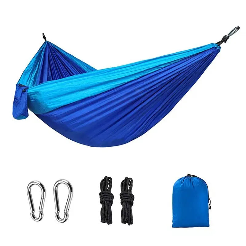 Blue parachute nylon outdoor hammock hung between two trees
