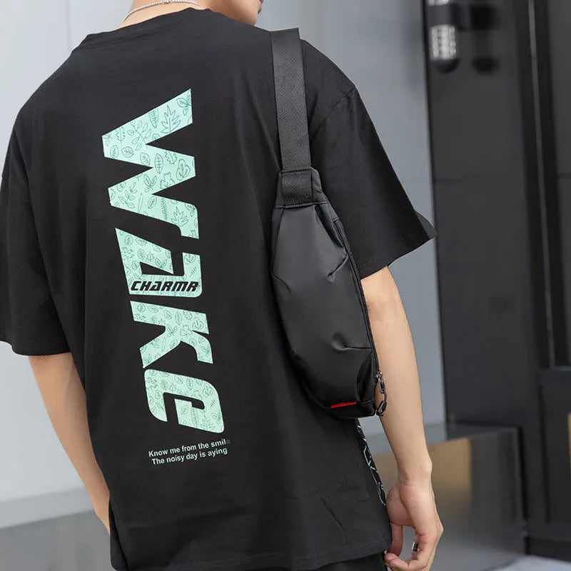 Black oxford cloth crossbody waist pack showing front zipper and strap.