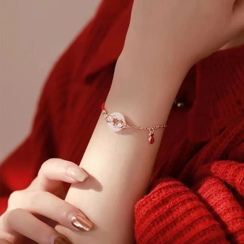 Festive koi bracelet with peace buckle charm on red rope, featuring fish tail decorative elements in Japanese style