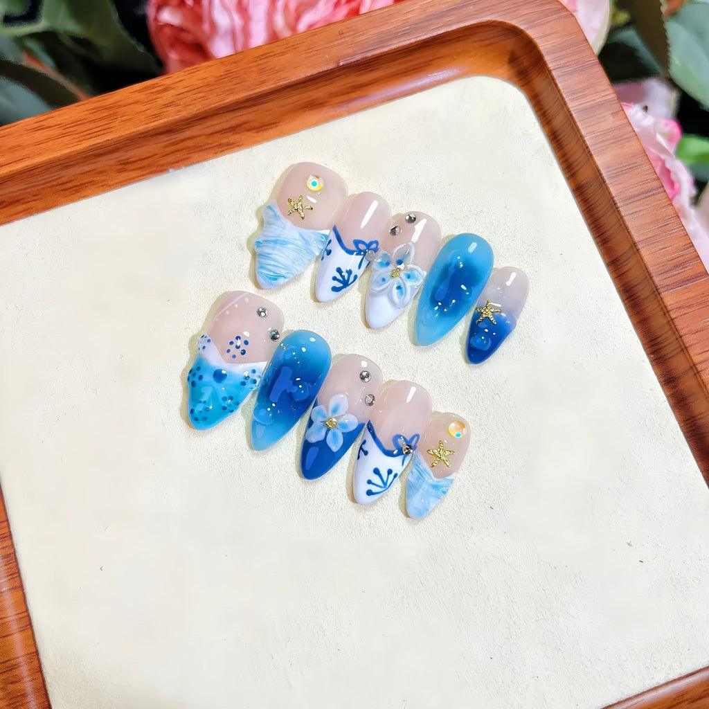 Blue hand-painted carved transparent fake nails set in sizes XS, S, M, L.