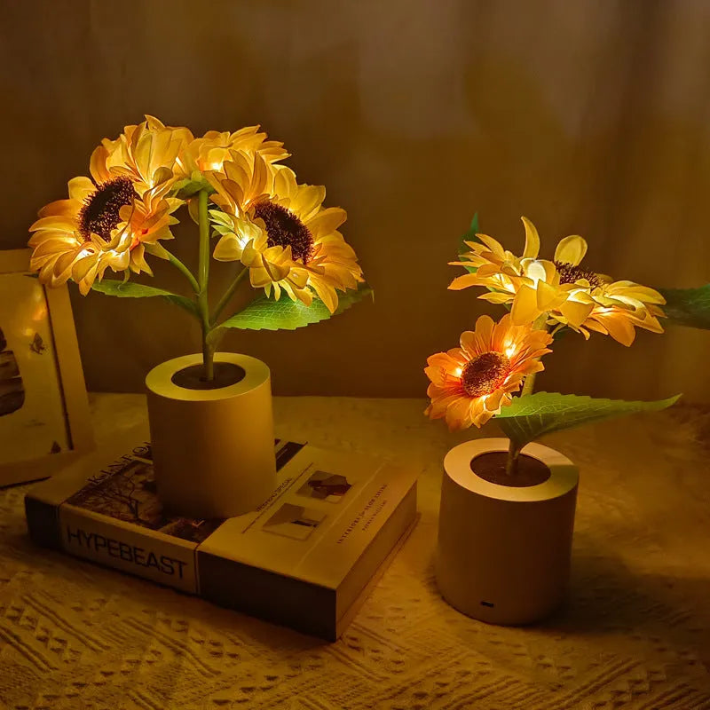 Rechargeable artificial sunflower LED table lamp with USB cable on wooden surface.