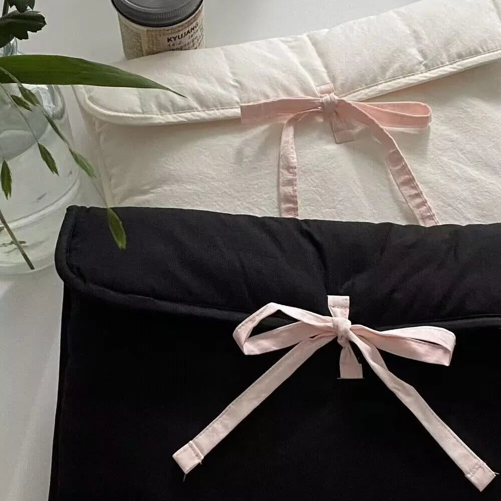 Women's black quilted laptop bag with bow detail and striped lining for 13-inch computers