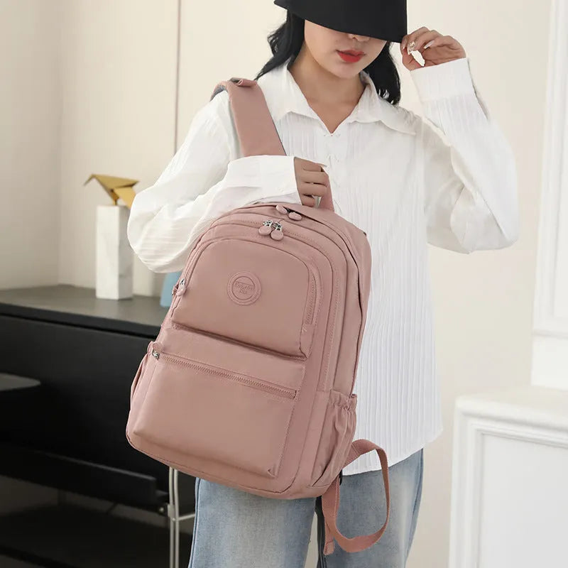 Women's large nylon travel backpack in celestite green showing front three-dimensional pocket and urban style.