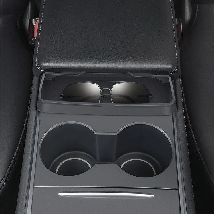 Black silicone sunglasses case mounted in a Tesla Model 3 or Y centre console.
