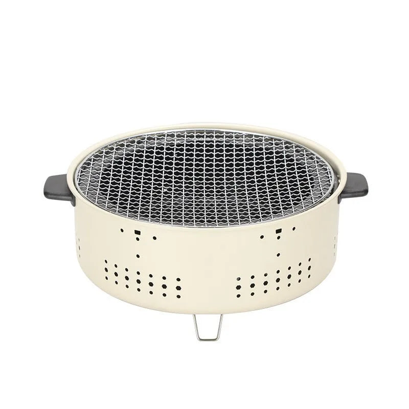 Portable indoor charcoal tea cooking stove with grill rack on a table.