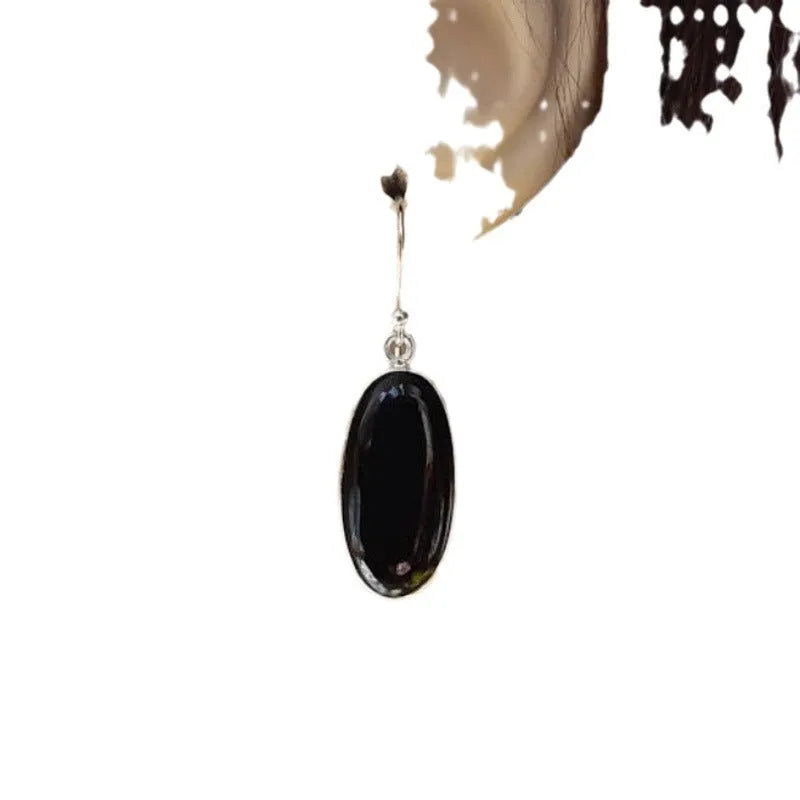Black oval geometric earrings with Chinese style design on an electroplated alloy construction.