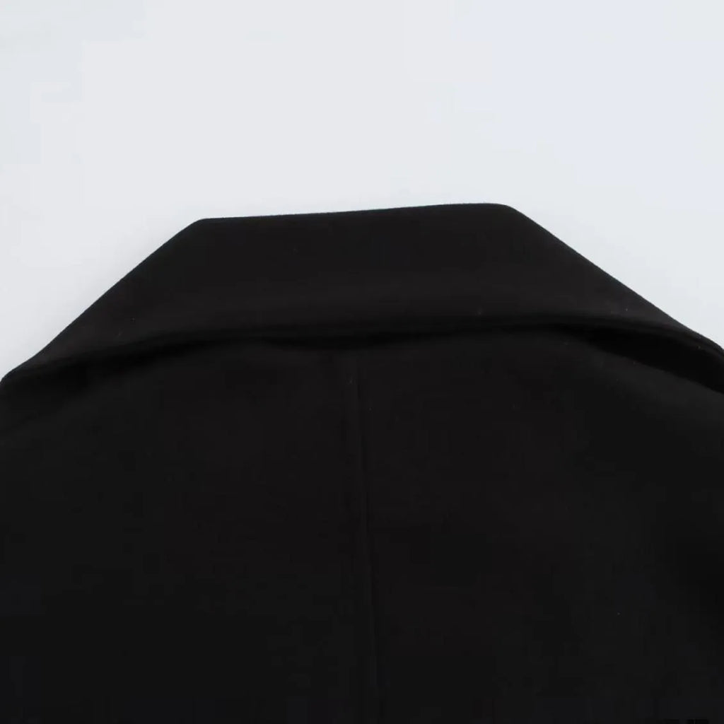 Long grey women's polyester overcoat with a black faux fur collar on a hanger.