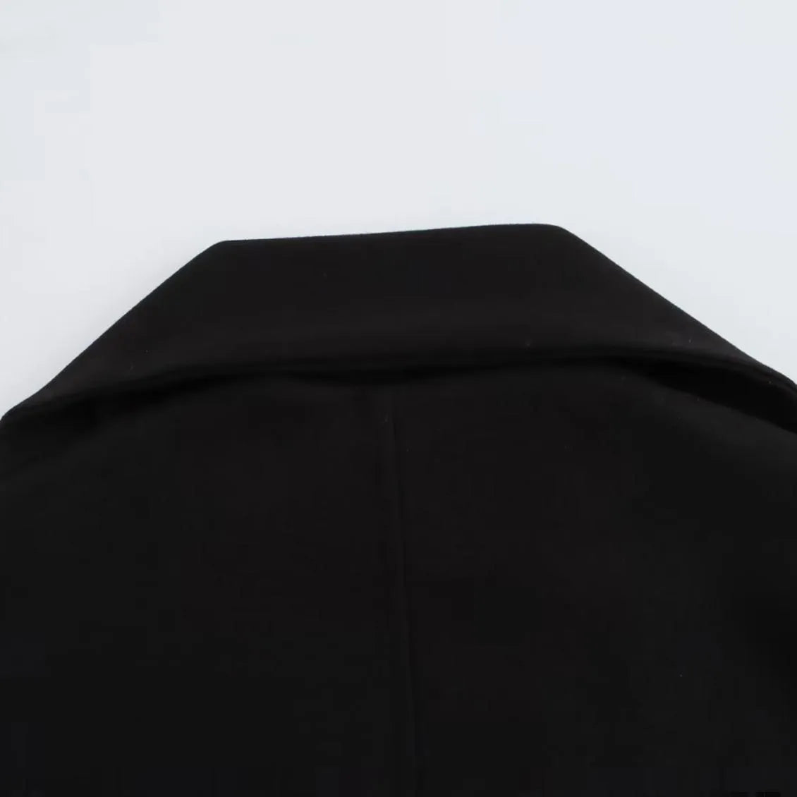 Long grey women's polyester overcoat with a black faux fur collar on a hanger.