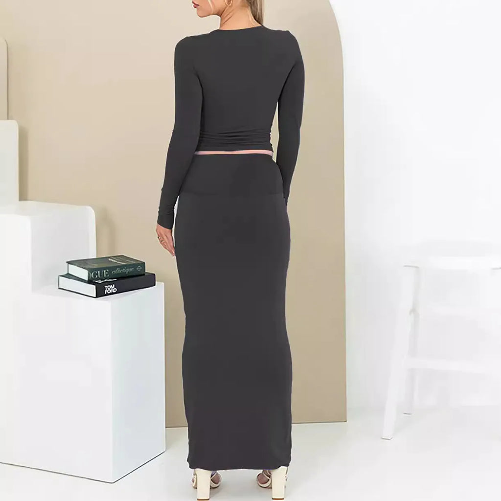 Women's slim fit polyester two-piece suit set with top, long skirt, and exposed navel detail.