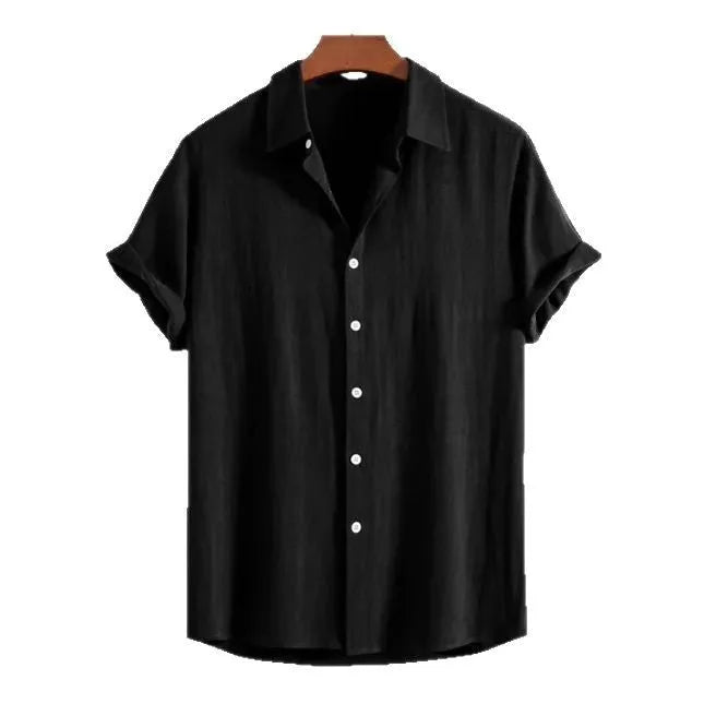 Man wearing a loose black short-sleeved cardigan on a beach, showing the casual summer style.