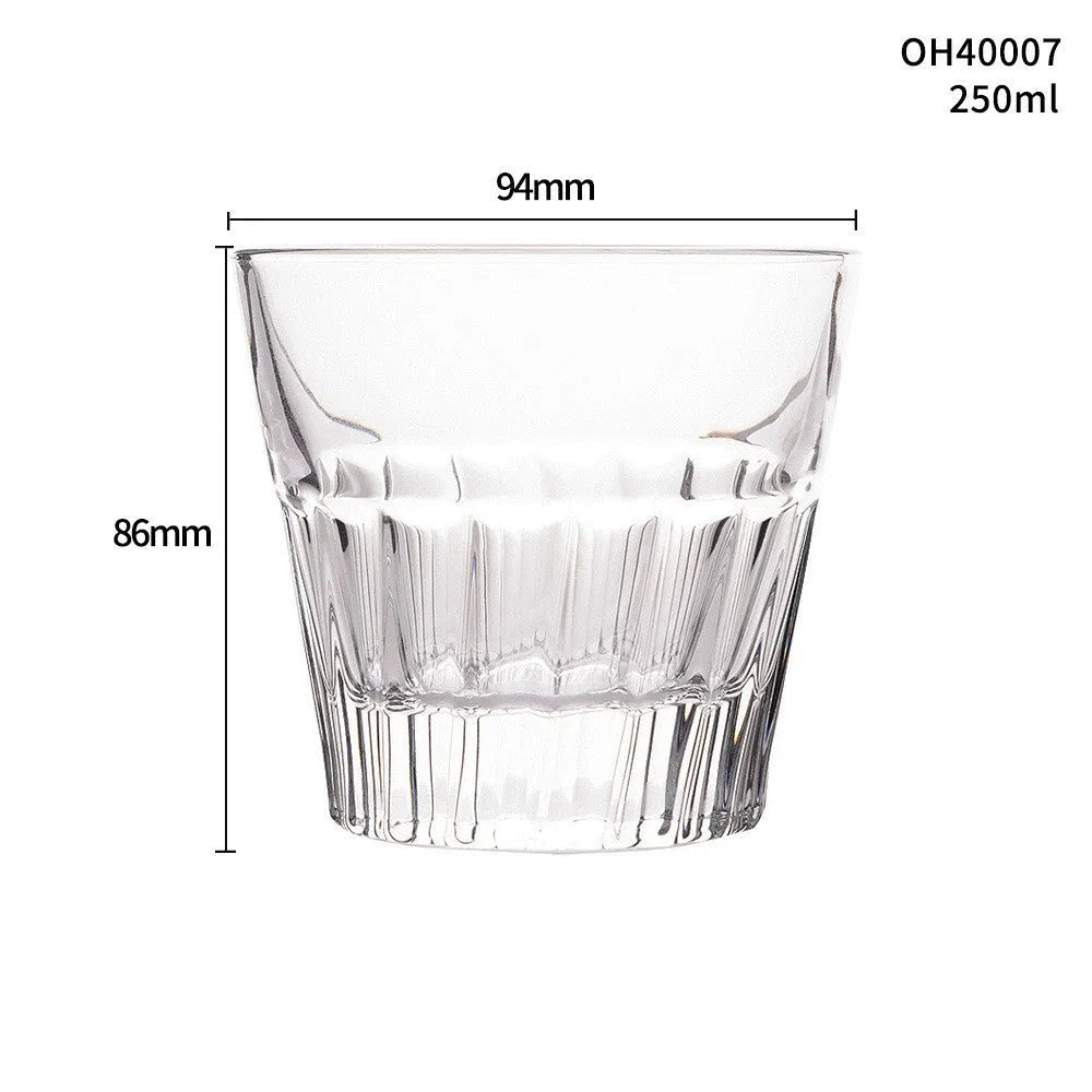 Clear whiskey shot glass with thick base and crystal design holding amber liquid