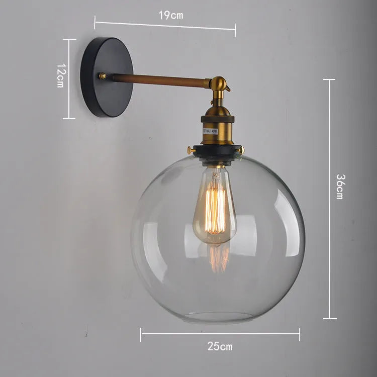 Close-up of a retro-style spherical glass wall lamp in amber, showing its aluminium holder and round shape.