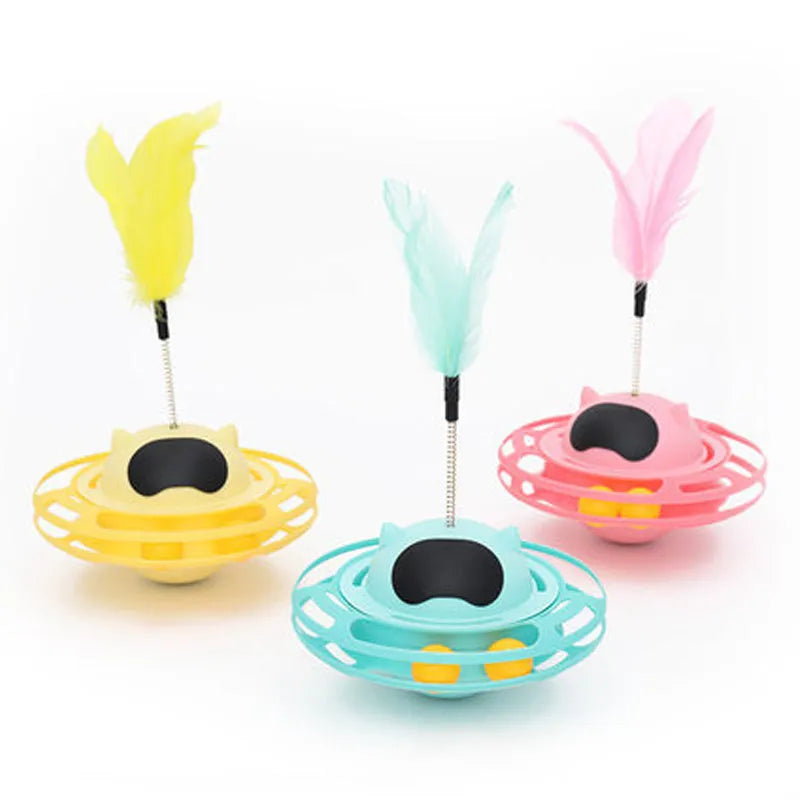 Pink cat tumbler turntable toy with a colourful baton on a flat surface.