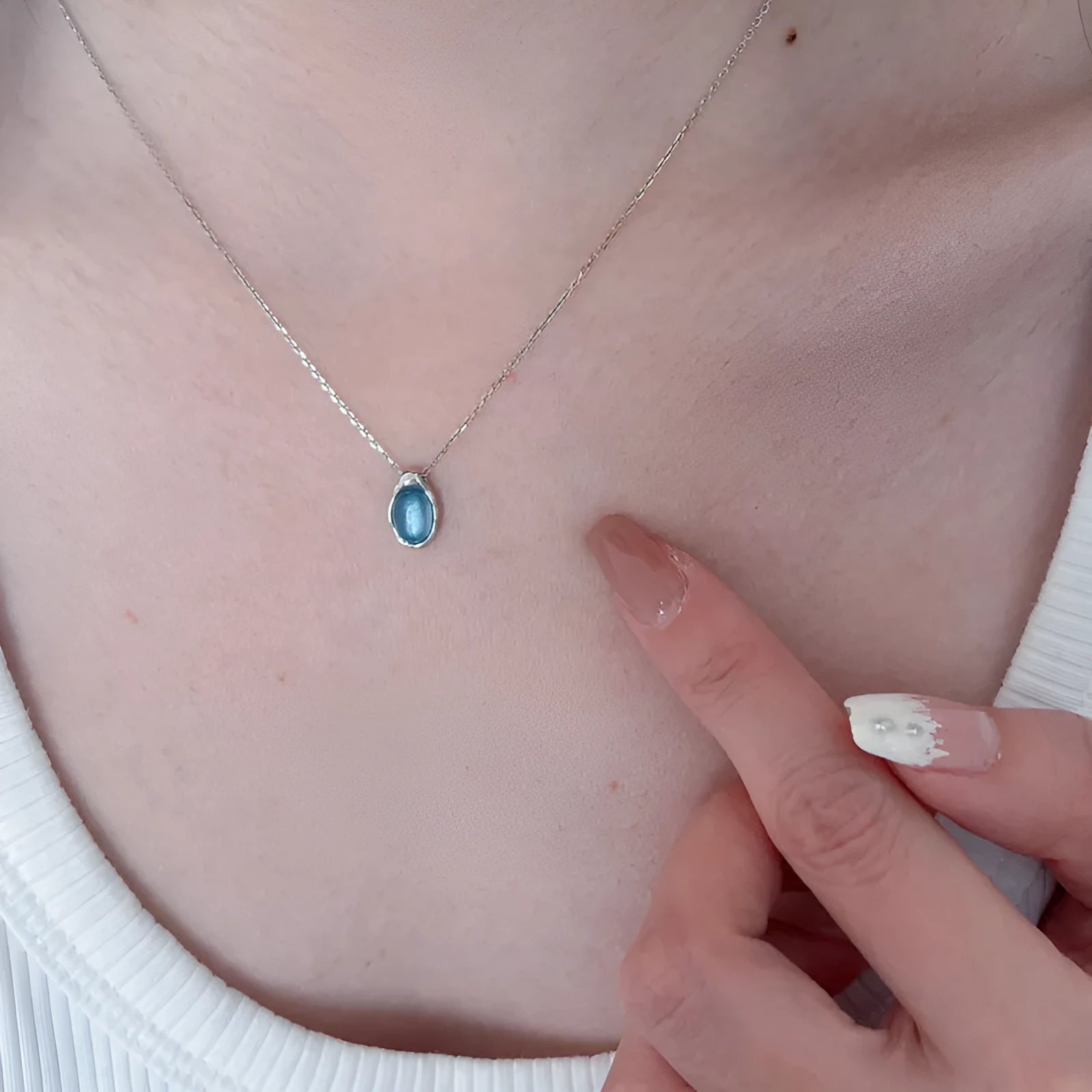 Geometric navy blue and platinum water drop pendant necklace on an adjustable copper cross chain.