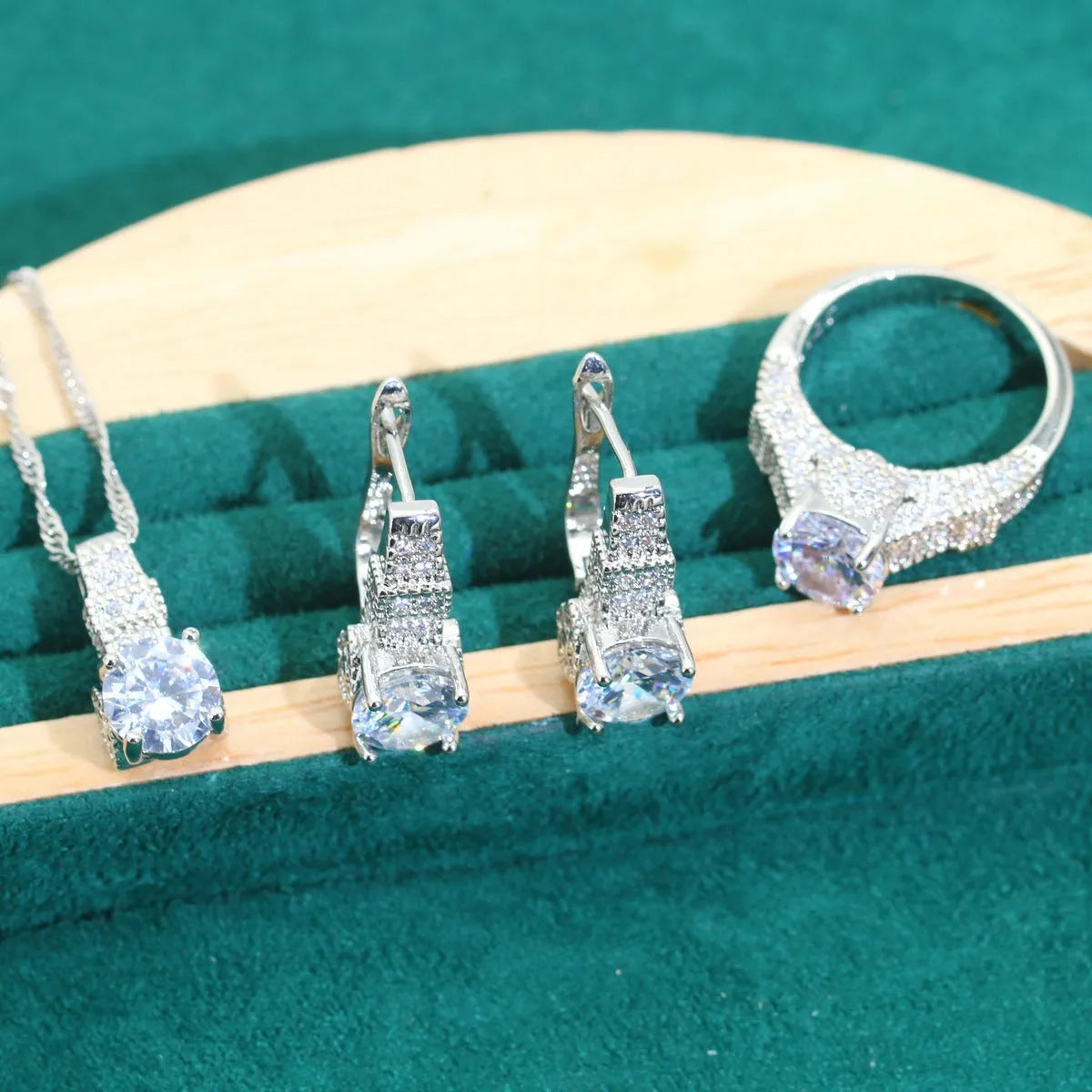 Four-piece bridal zircon jewellery set showing necklace with water wave chain, bracelet, earrings, and ring in alloy with coloured zircon stones