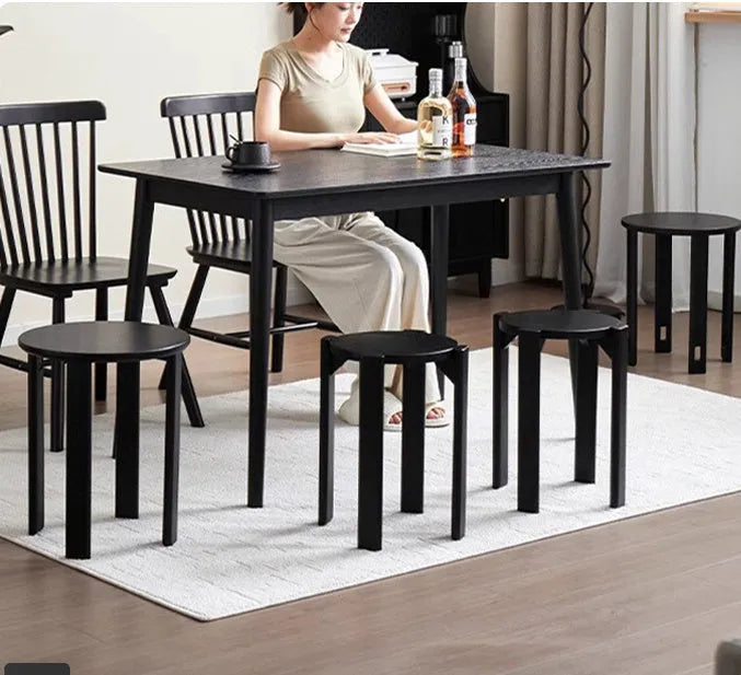 Stackable iron dining stool with large round seat in smoked black finish.