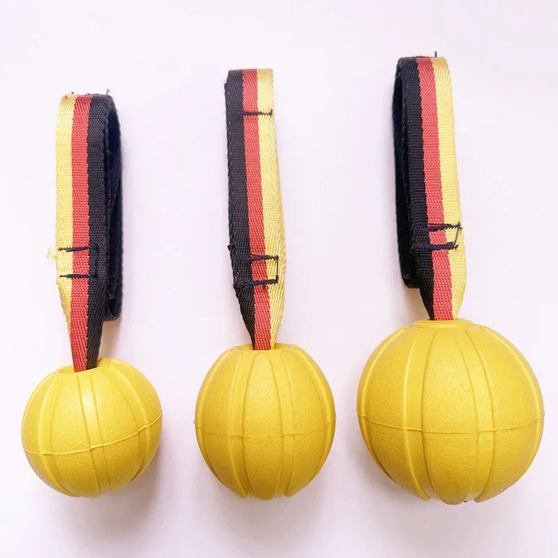 Yellow and camouflage coloured EVA floating dog balls with strings in three different sizes on a blue background.