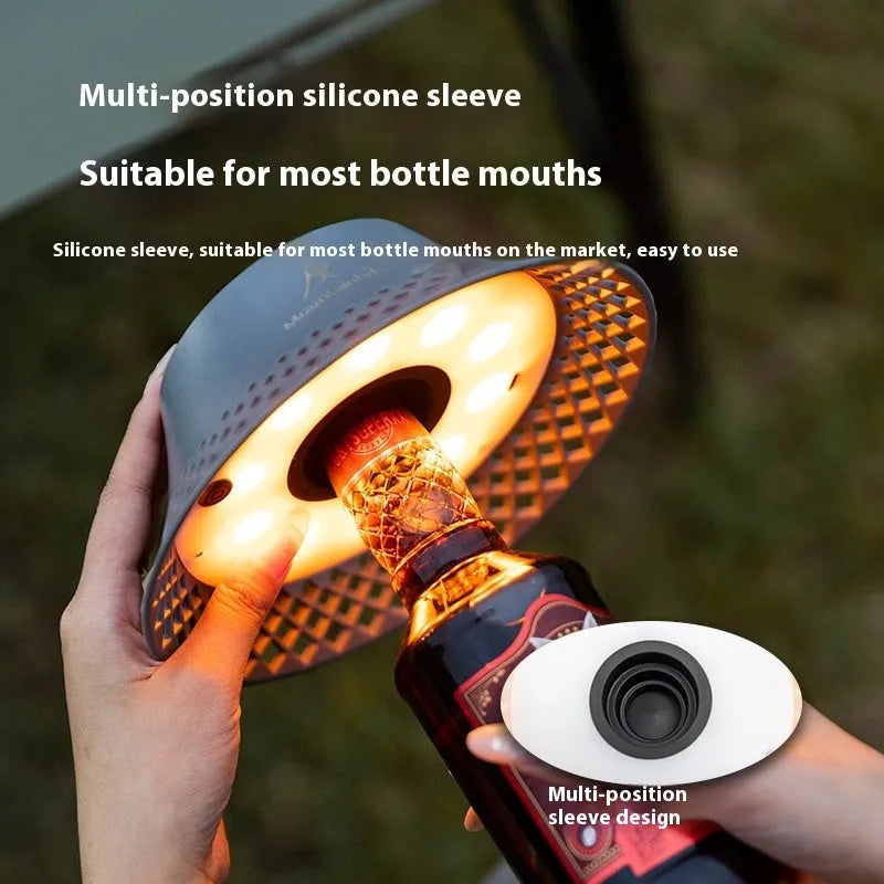 Beige portable camping lantern with a wine bottle shaped shade and USB Type-C charging port.