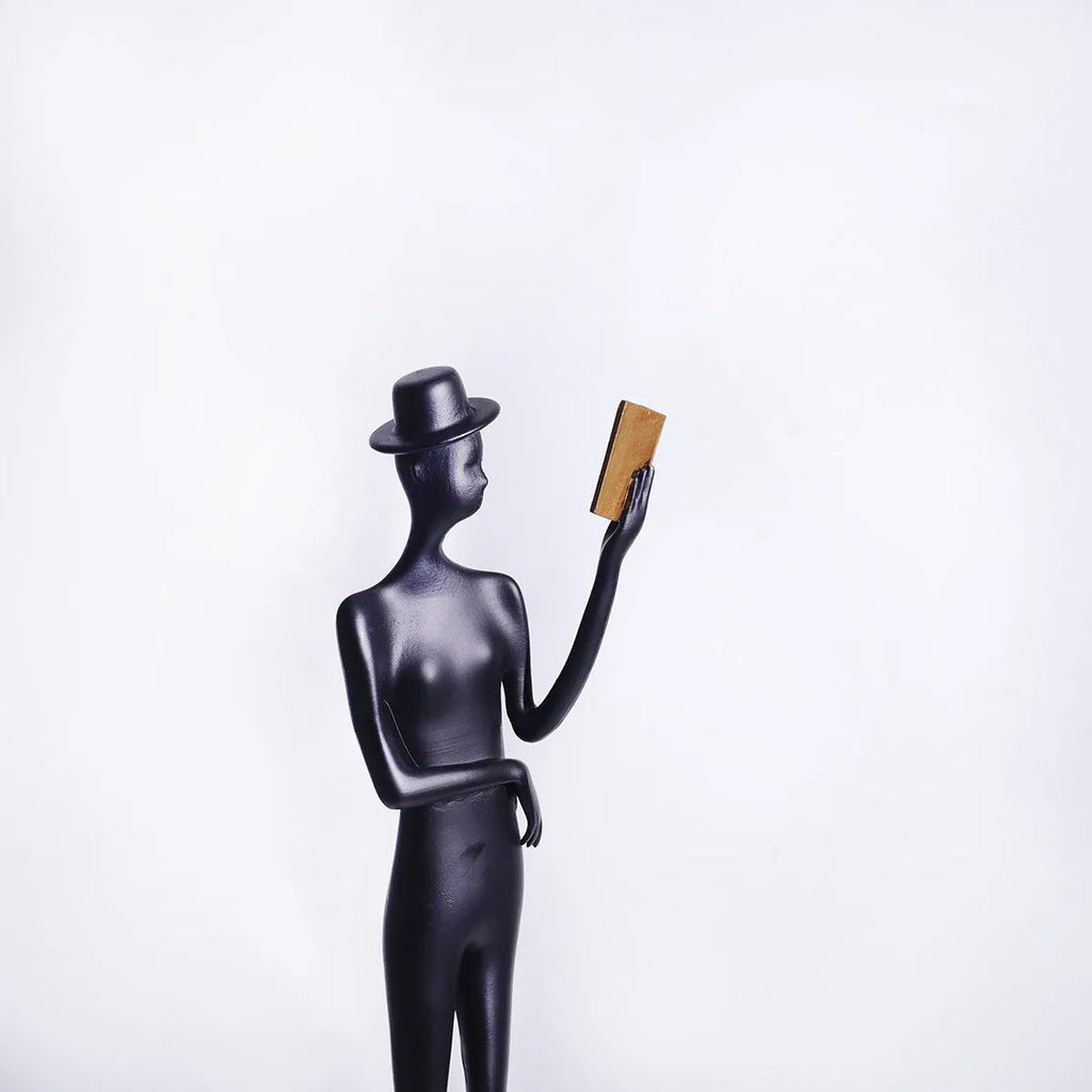 Black cast aluminium desktop sculpture of a reading woman, modern simplicity style