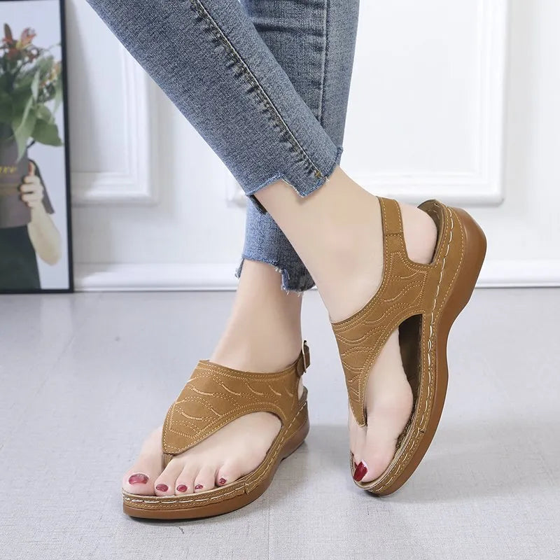 Women's black wedge heel sandals with an adjustable buckle back strap on a plain background.