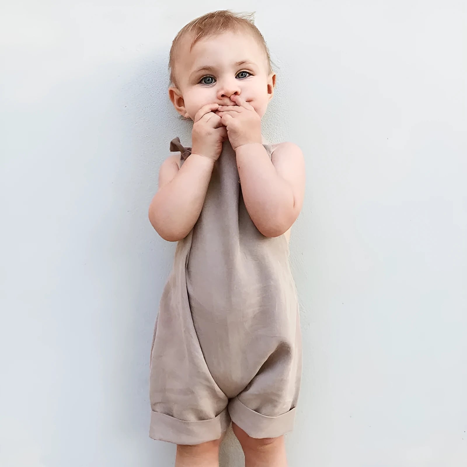 Children's khaki cotton overalls shorts with bow detail and straps, front view
