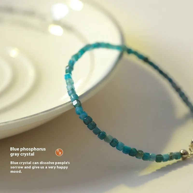 Women's blue and grey crystal bracelet with diamond faceted beads on a wrist.
