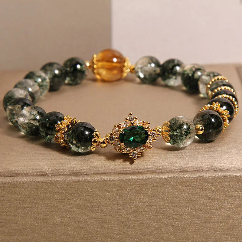 Women's green phantom quartz crystal bracelet with gold rutile needles, ruby quartz bead, pearls, and rhinestone details.