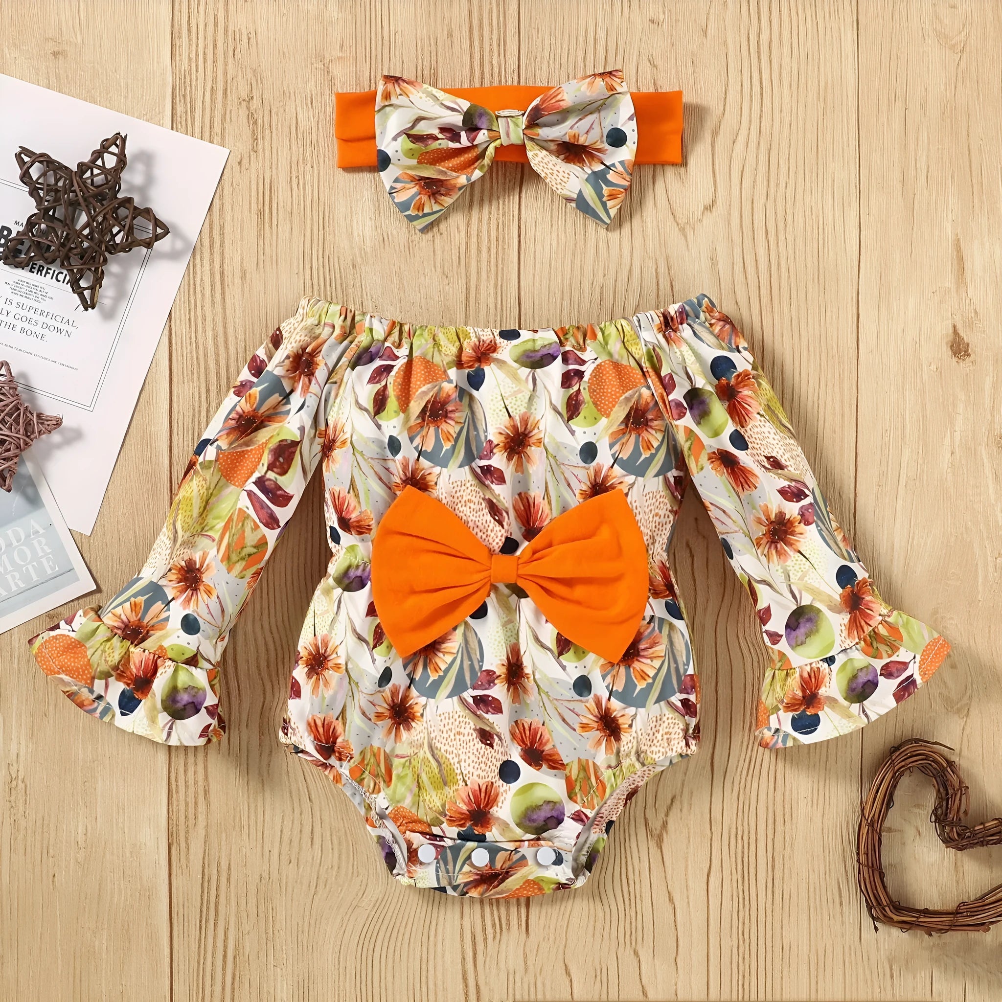 Baby wearing a floral flare sleeve romper band set with matching headband on a neutral background