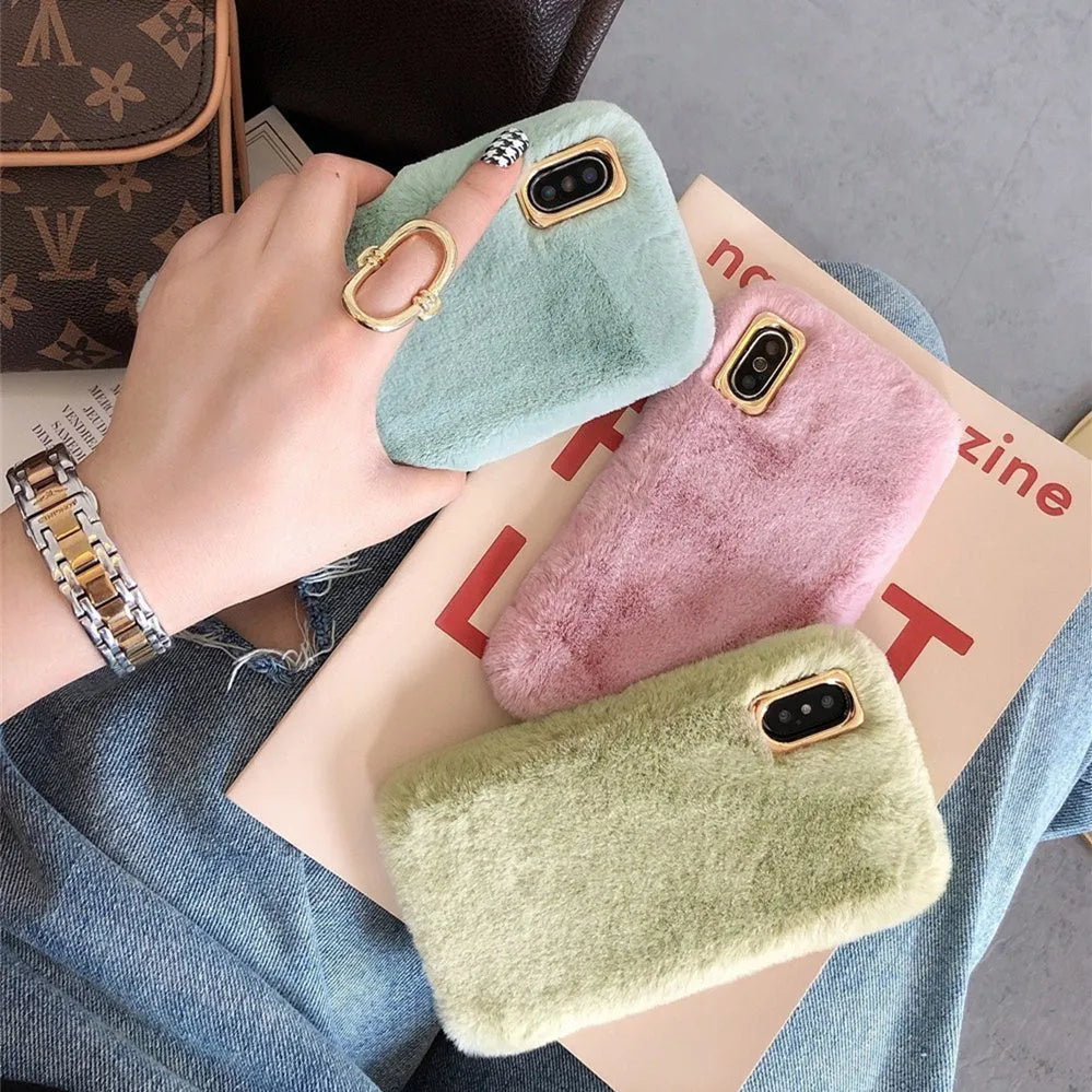 A pink rabbit plush phone case next to a silicone shell, showing the raised camera circle.
