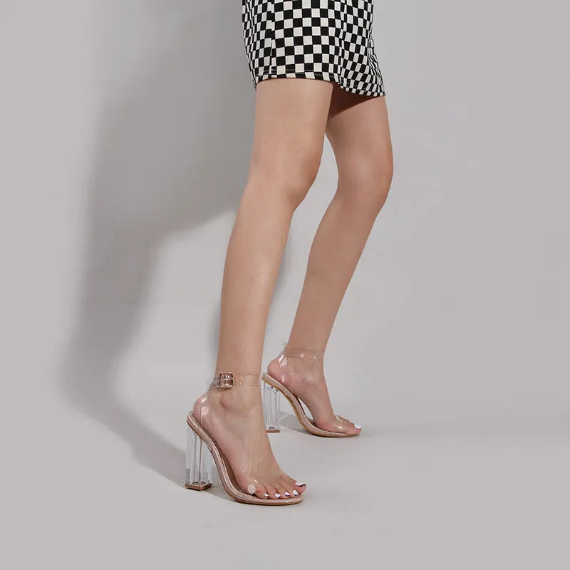 Apricot-coloured women's high heel sandals with a clear glass heel and a buckle strap fastener.