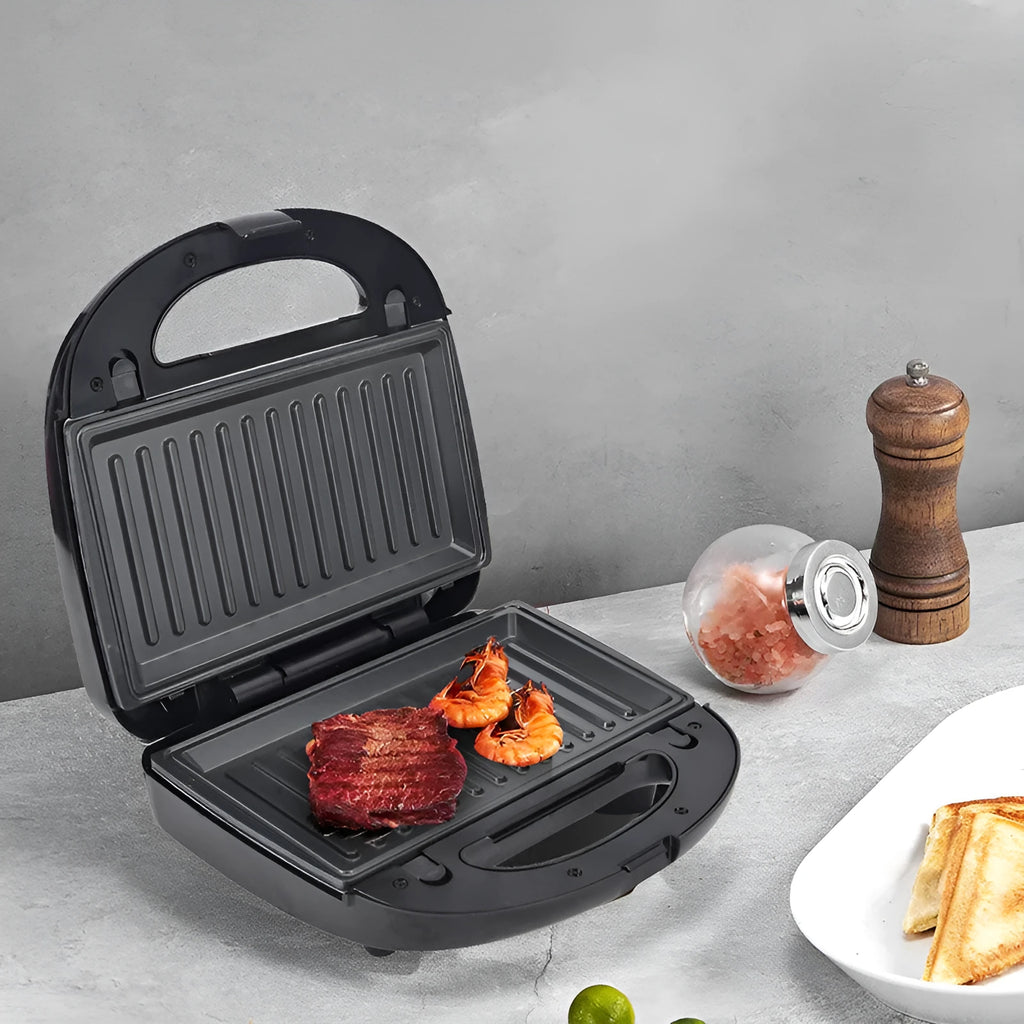Black double-sided electric sandwich pan with stainless steel lid and six non-stick baking pans.