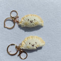 Handmade crochet dumpling pendant with keychain in plush material showing hand-stitched eye details