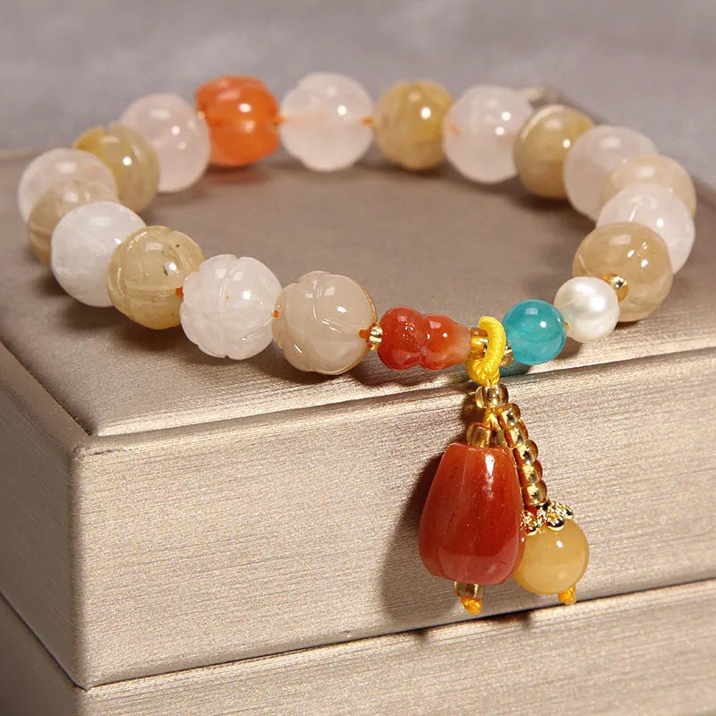 Yellow agate crystal bracelet with gold silk cord on wrist showing adjustable closure and bead detail