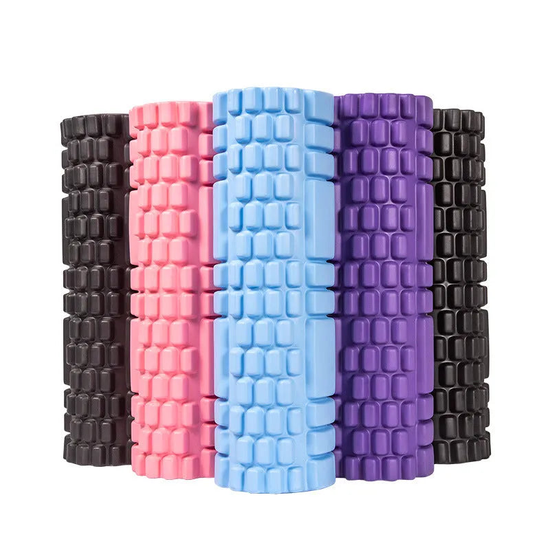 A black EVA foam roller on a gym floor, showing its cylindrical shape and texture.