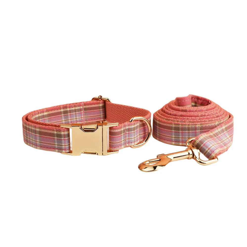 Plaid fabric dog collar, leash, bow, and vest four-piece accessory set on a white background.
