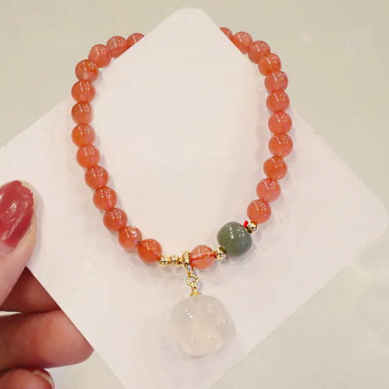 Natural red agate bracelet with jade beads and a Cat's Paw charm, showing 8mm agate beads and gem inlay detail.
