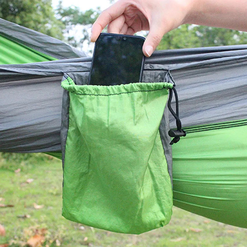 Blue parachute nylon camping hammock hung between two trees showing its full 270cm length.