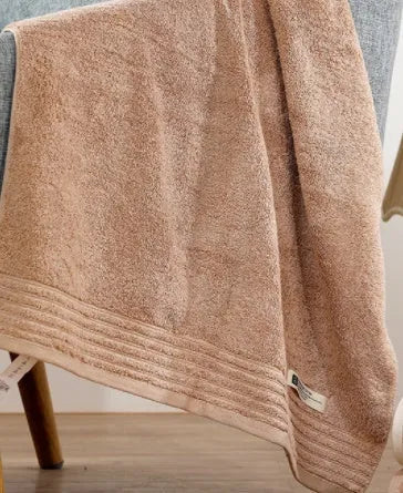 Beige and brown cotton towel set showing face cloth, hand towel and bath towel sizes.
